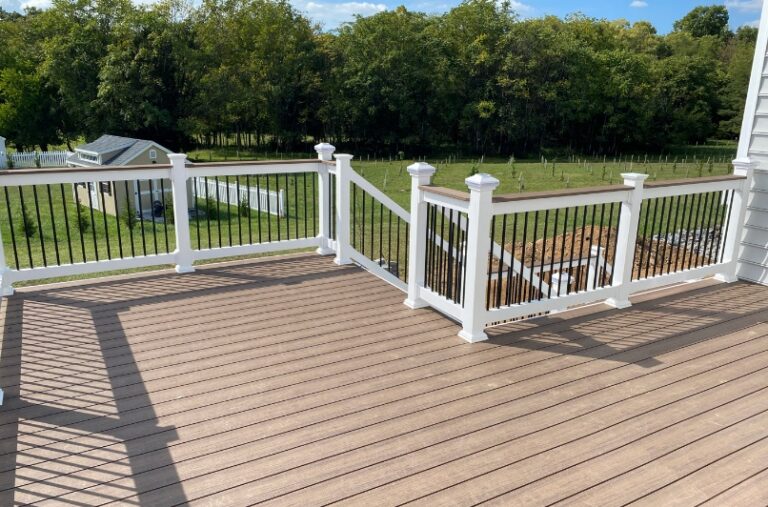 light brown composite wood deck with white deck railings