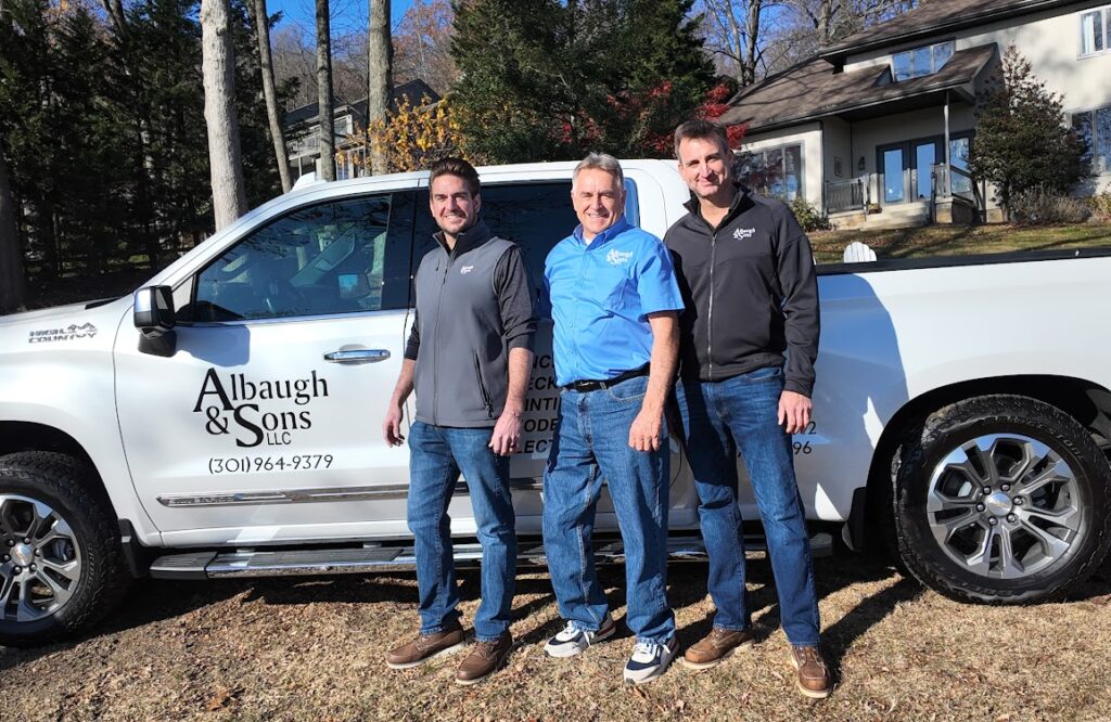 3 owners of Albaugh & Sons standing together by a white Albaugh & Sons branded pickup truck